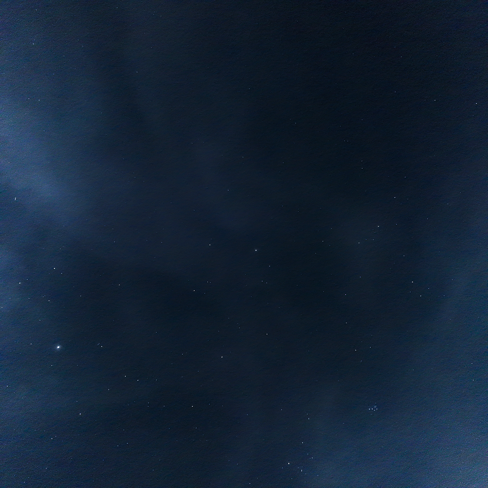 A field of stars across a deep blue night sky, with Jupiter visible as a bright point near the bottom of the frame
