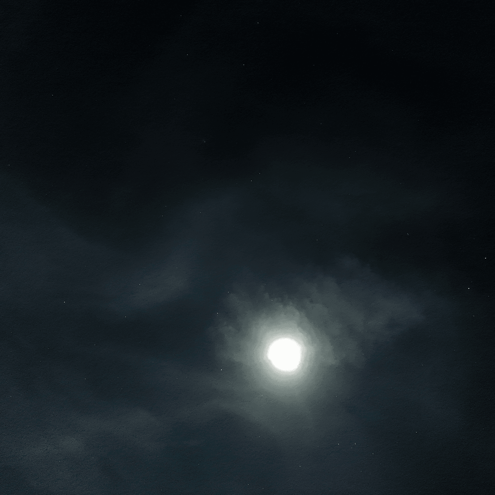 The Moon breaking through drifting clouds over a dark Minnesota sky, captured on a DJI Osmo Pocket 3